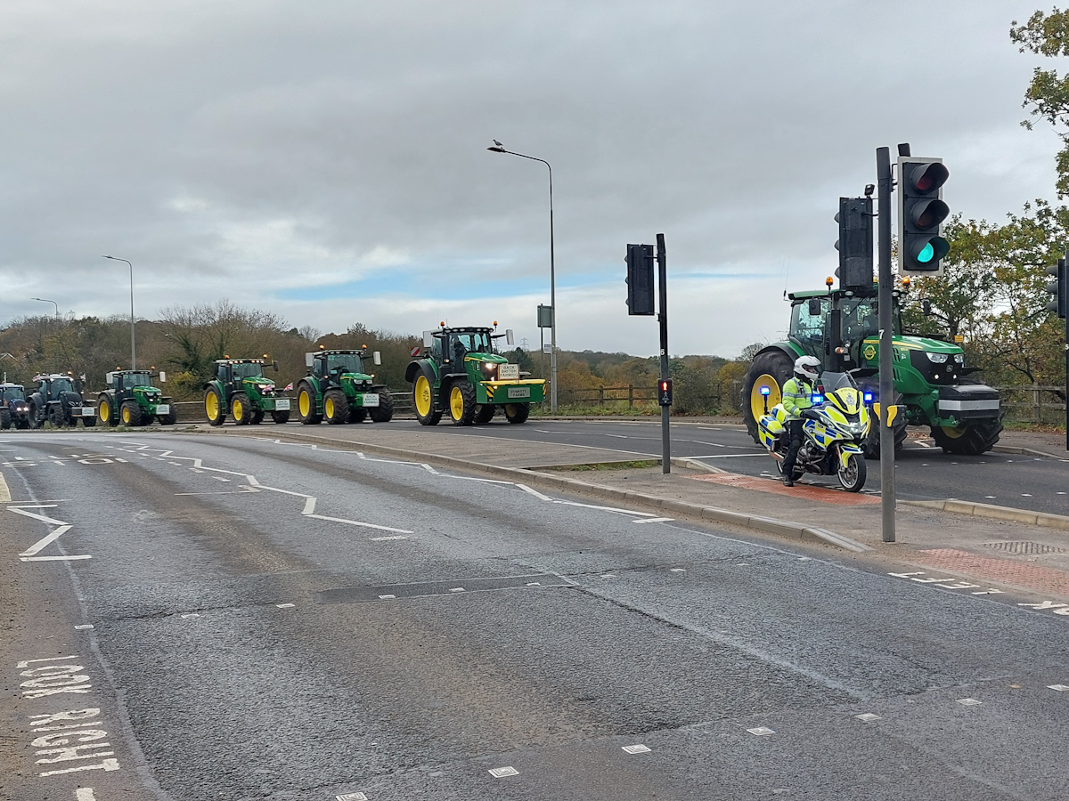 A police motorcycle escorted tractors